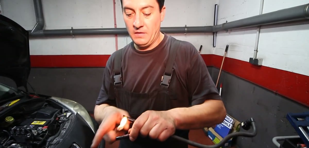 Calentando el tubo de gasoil con un mechero para meter el empalme