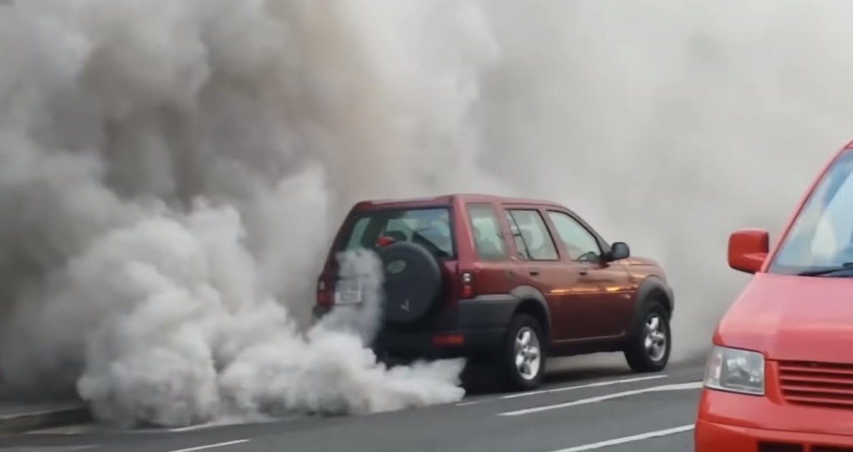 coche diésel en autoencendido soltando una gran cortina de humo