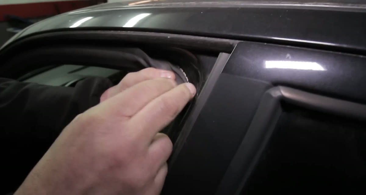 Bajando la goma de la puerta para ver si el coche ha sido repintado
